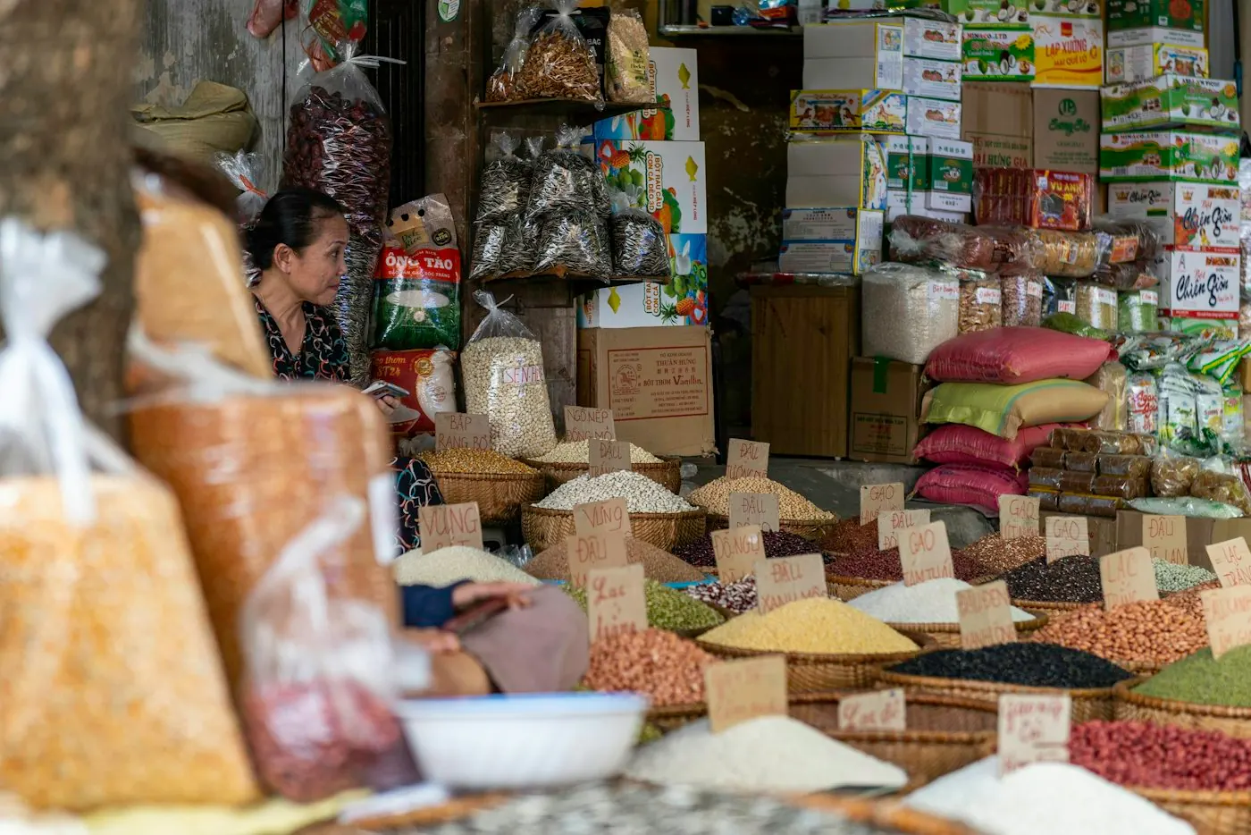 Chủ cửa hàng hàng khô bên quầy gạo, đậu và hạt